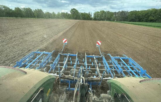 Blick aus dem Traktor nach hinten auf eine Egge