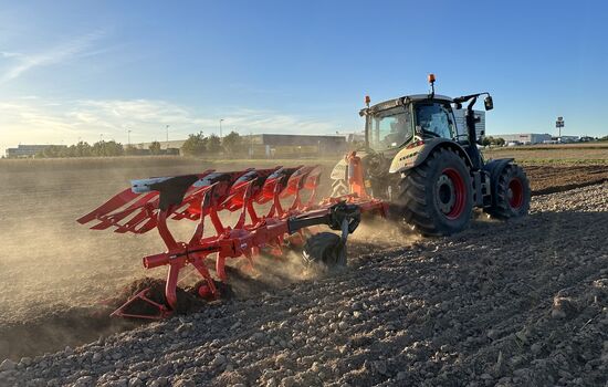 Traktor mit Wendepflug - Drehpflug bei der Arbeit auf dem Acker
