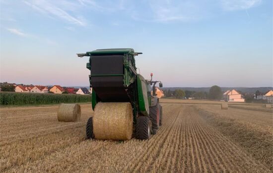 auf einem Acker Presst eine Strohballen Presse Stroh