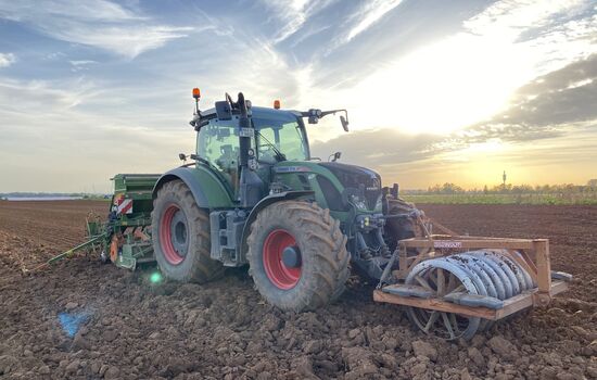 Traktor mit Sämaschine und Disk Walze bei der Arbeit